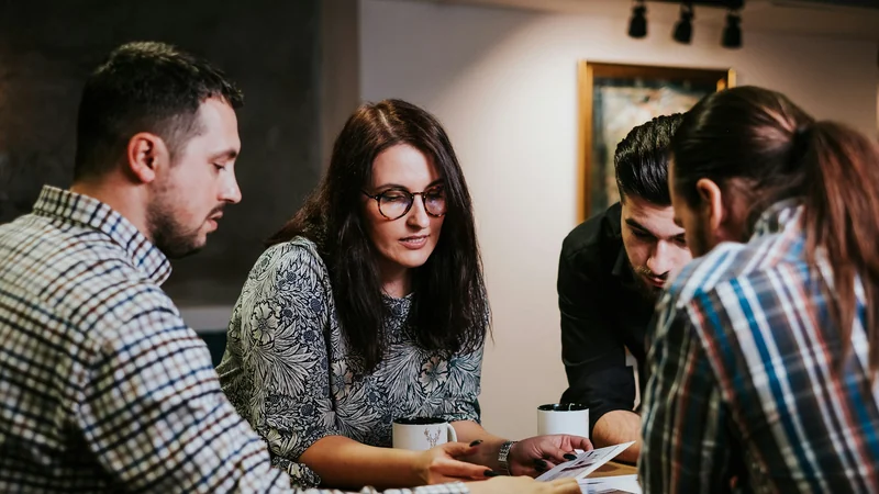 Four colleagues reviewing documents together at a table, comparing options for a new system.
